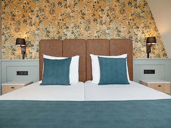 Hotel room twin bed with floral wallpaper