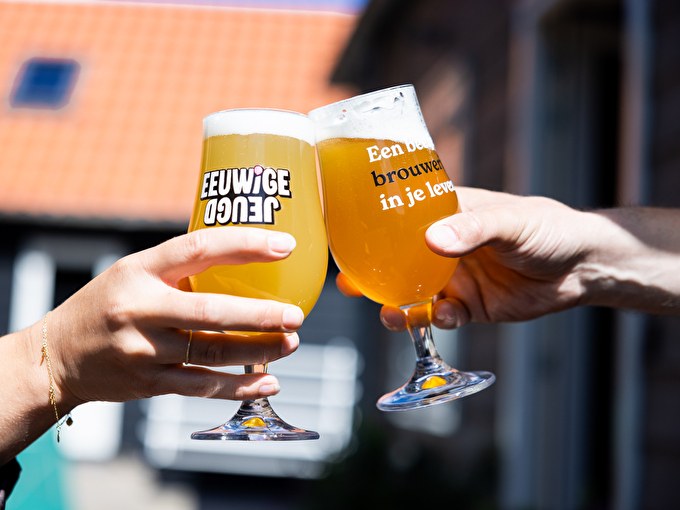 Photo of two people cheering with a beer at the hotel