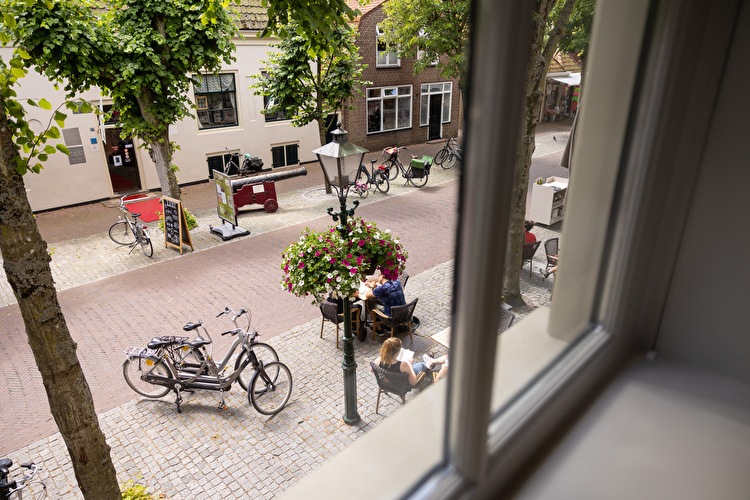 Foto van de Dorpsstraat vanuit de hotelkamer