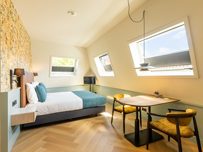 Photo of a hotel room with a desk and a chair